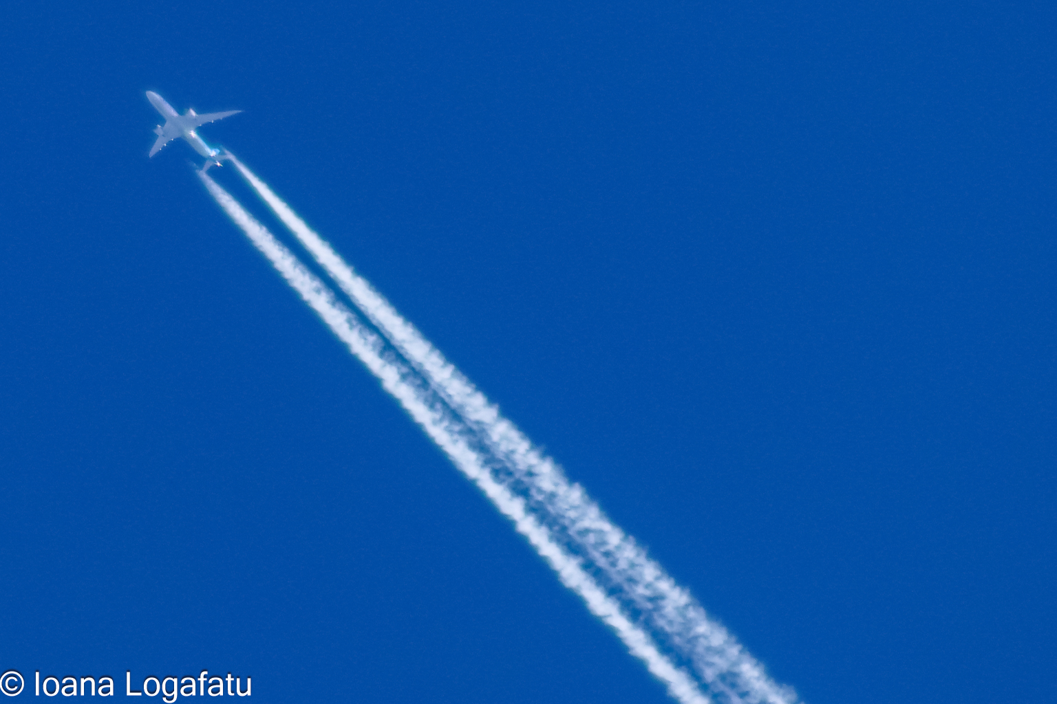 High in the sky, a jet leaves its mark of clouds